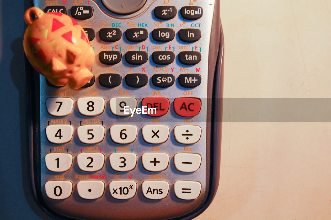Close-up of piggy bank figurine on calculator