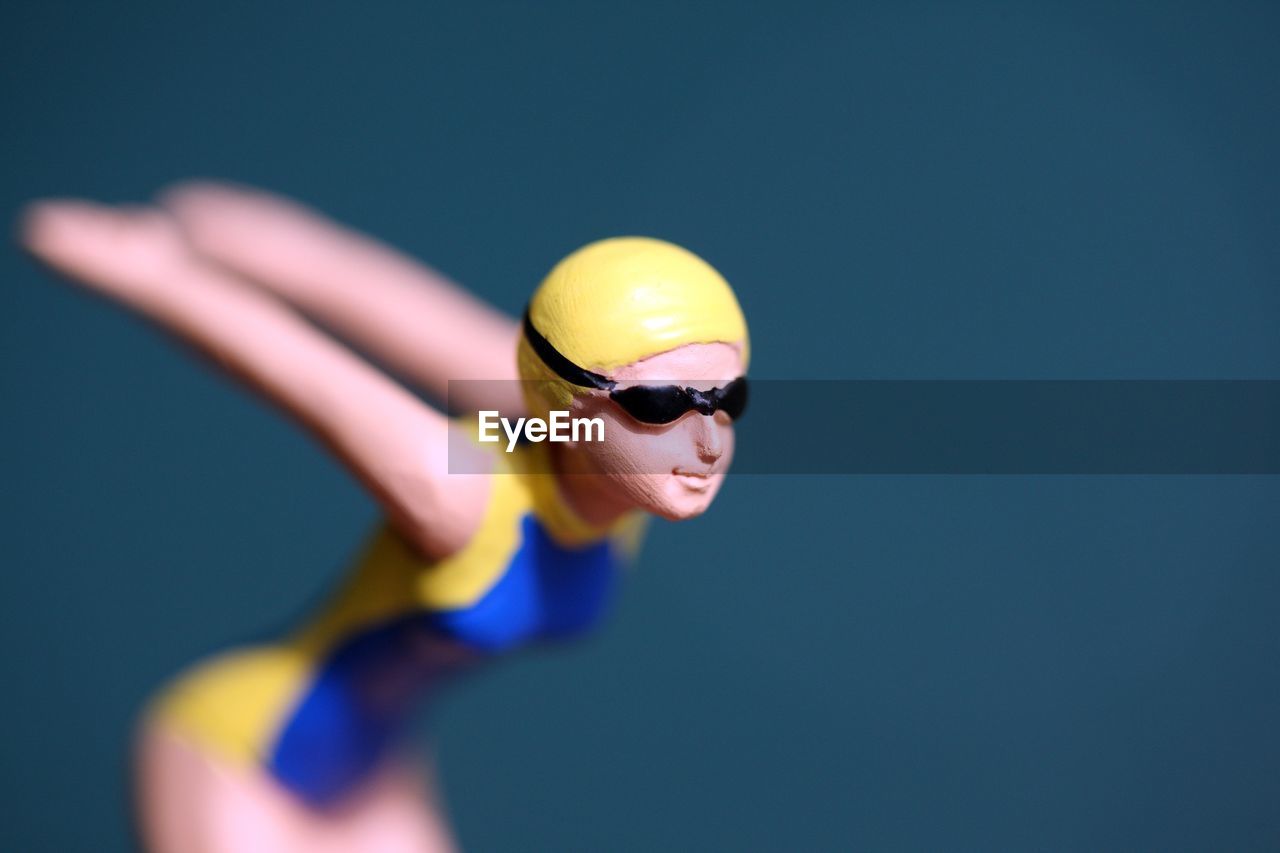 Close-up of swimmer cake figurine against blue background