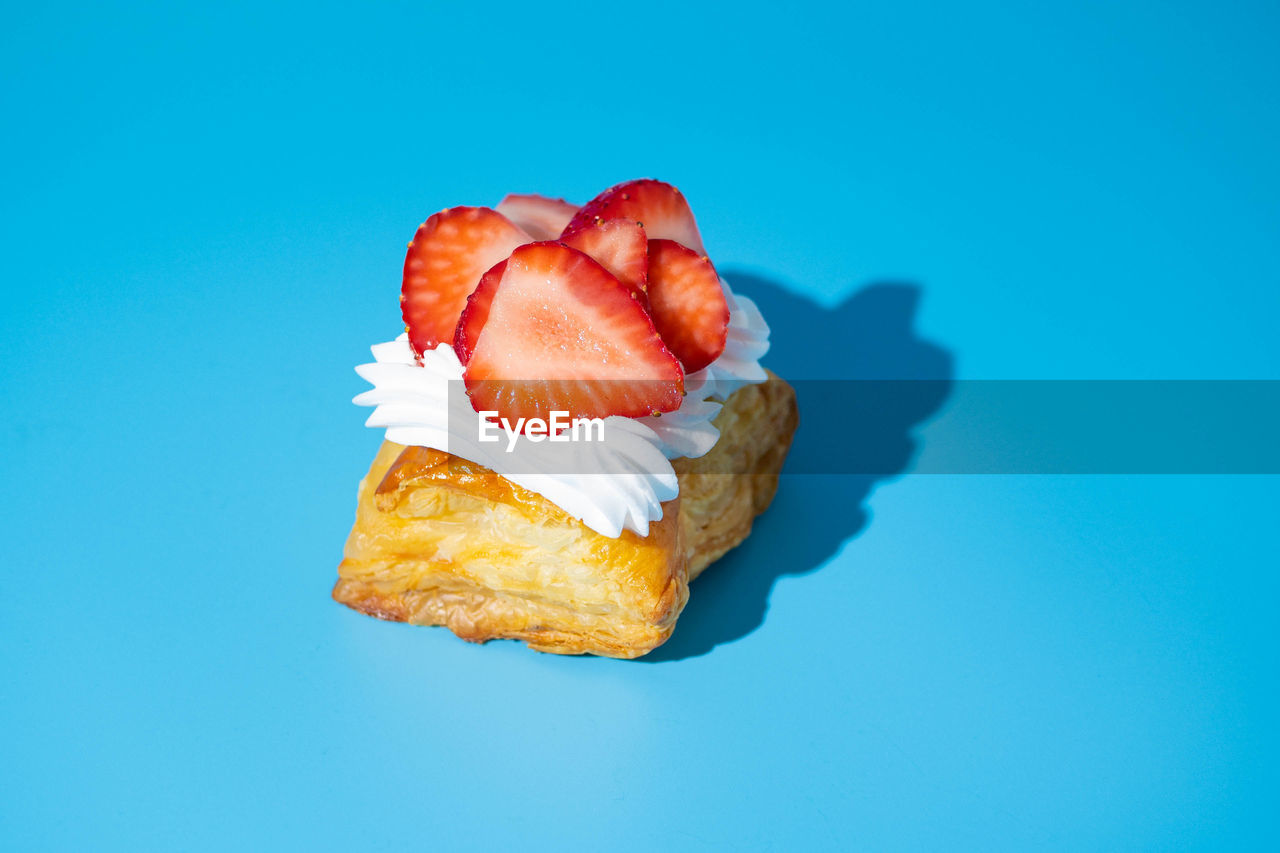 CLOSE-UP OF STRAWBERRY ON BLUE BACKGROUND