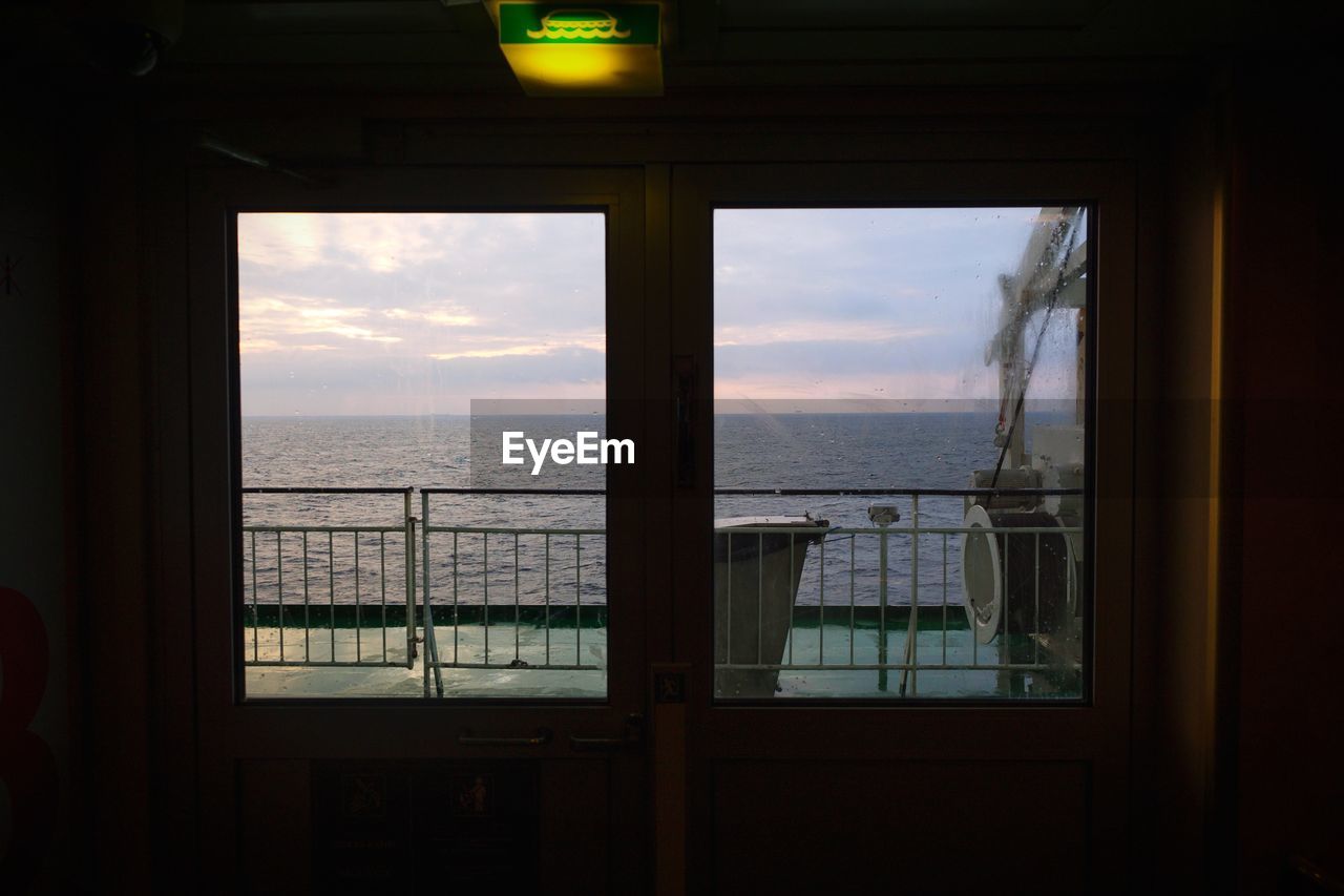 SEA AGAINST SKY SEEN THROUGH WINDOW