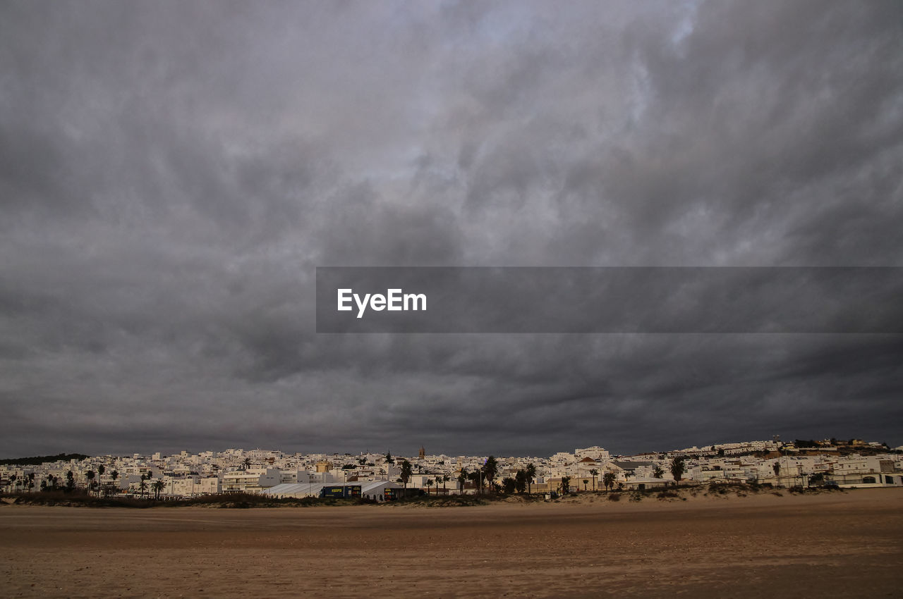 City by sea against storm clouds
