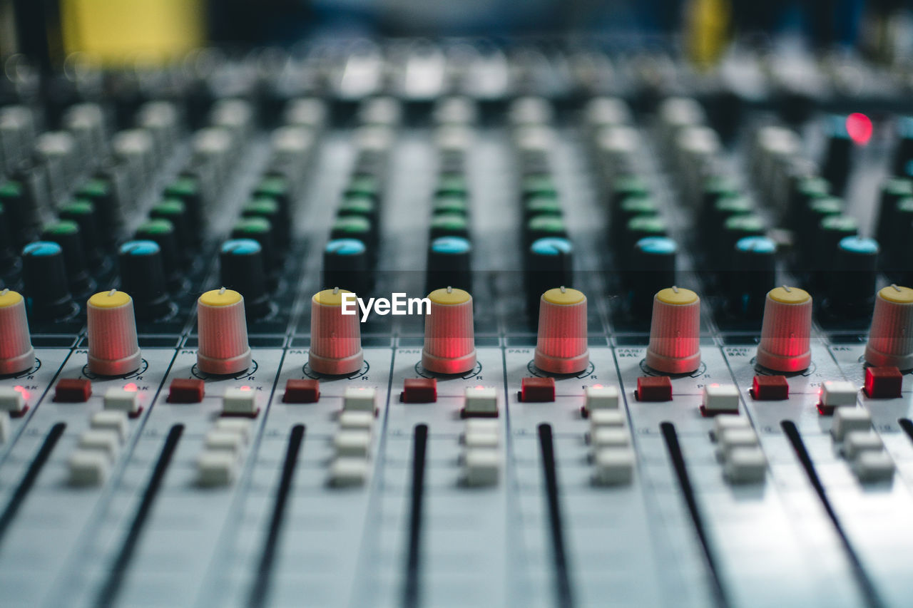 Close-up of knobs and push buttons on sound mixer