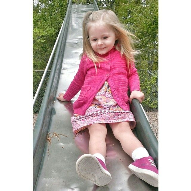 Cute little girl sitting on slide