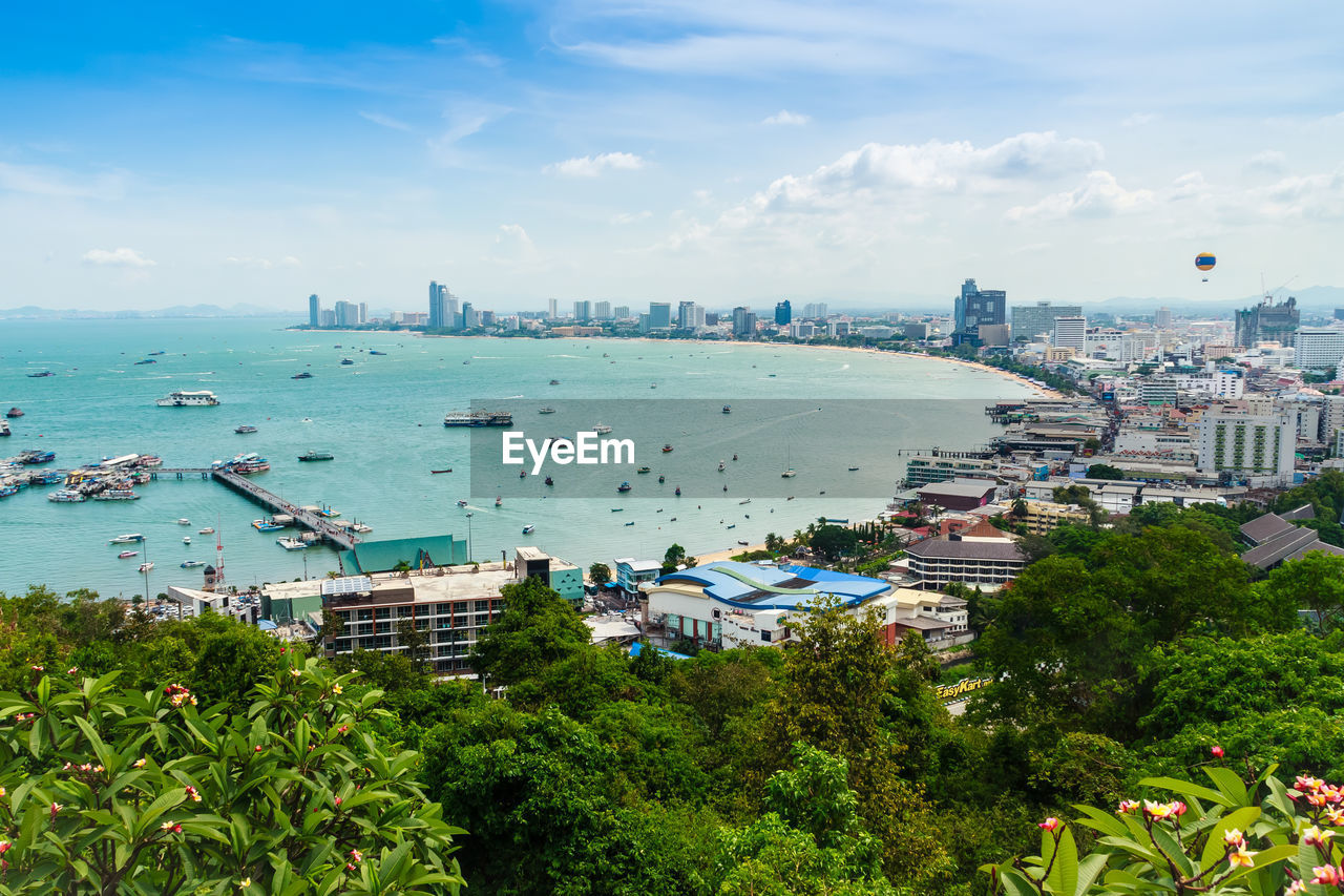 High angle view of cityscape by sea against sky