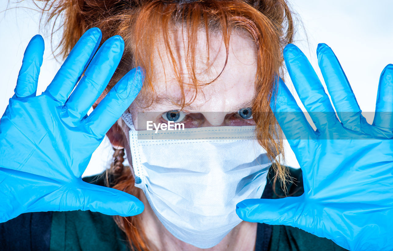 Portrait of a woman, she is wearing a medical mask and hygiene gloves