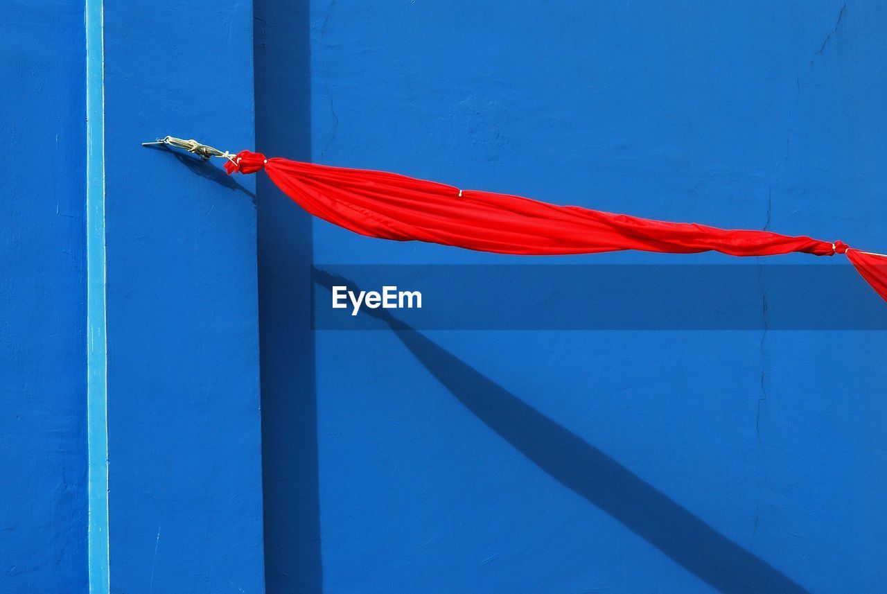 Red cloth tied against blue wall