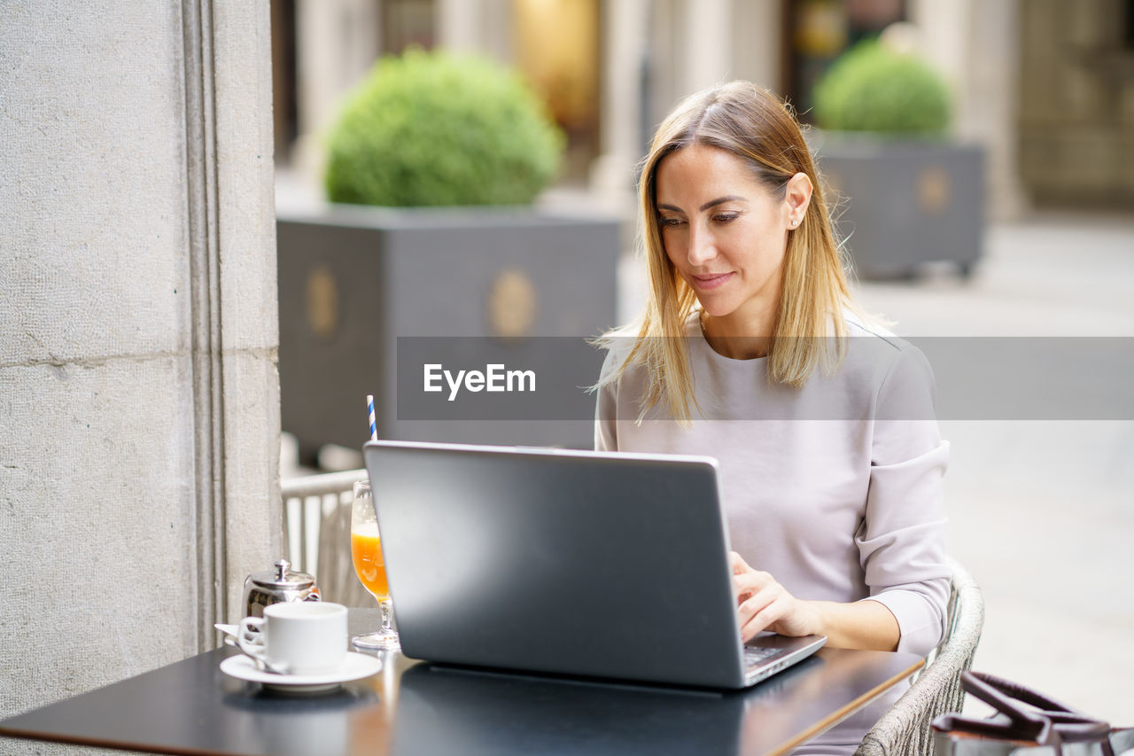 young woman using laptop while sitting at office