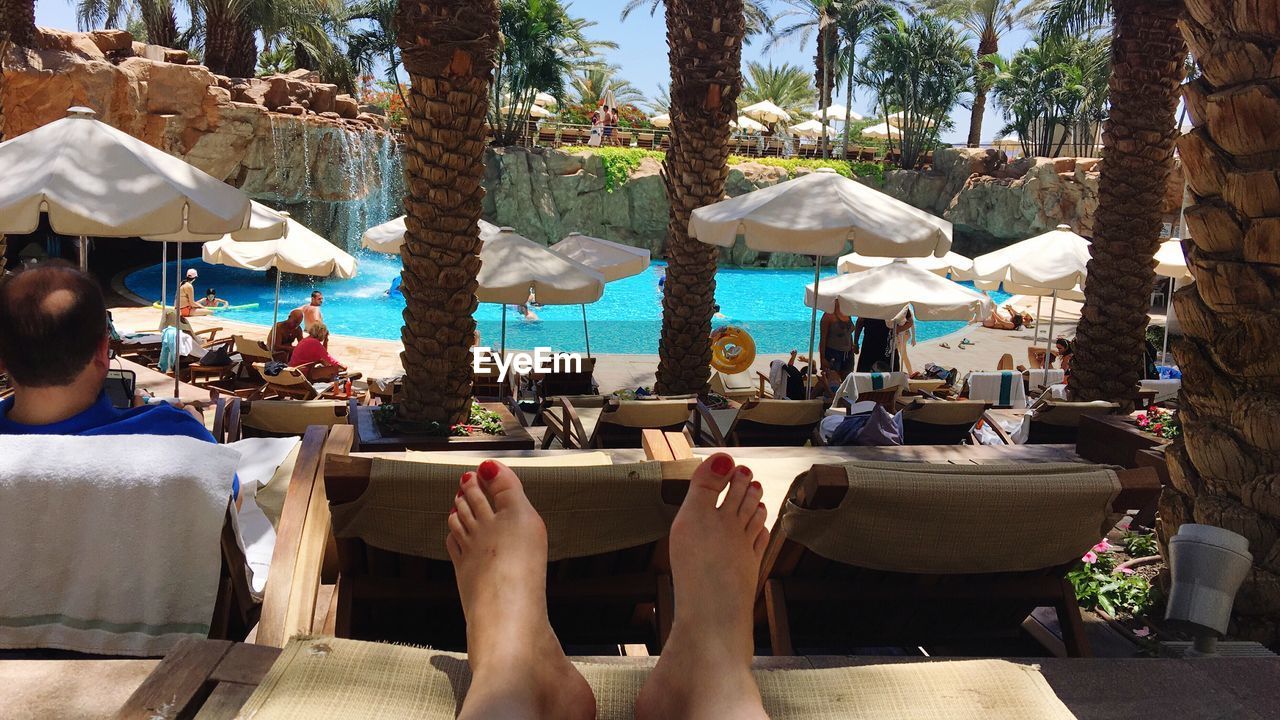 WOMAN RELAXING IN SWIMMING POOL