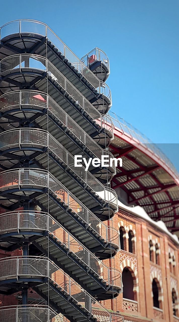 Low angle view of staircase by building against clear sky