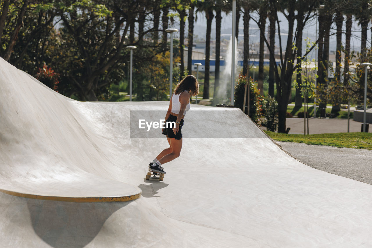 Woman skateboarding on sports ramp