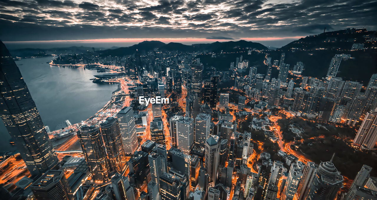 High angle view of illuminated city against sky at dusk