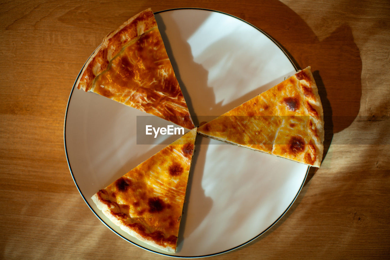 food and drink, food, directly above, table, indoors, freshness, fast food, no people, high angle view, wood, unhealthy eating, baked, dish, dessert, still life, snack, close-up, shape, plate, slice, pizza, sweet food