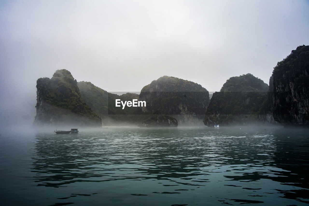 Scenic view of sea and mountains against sky