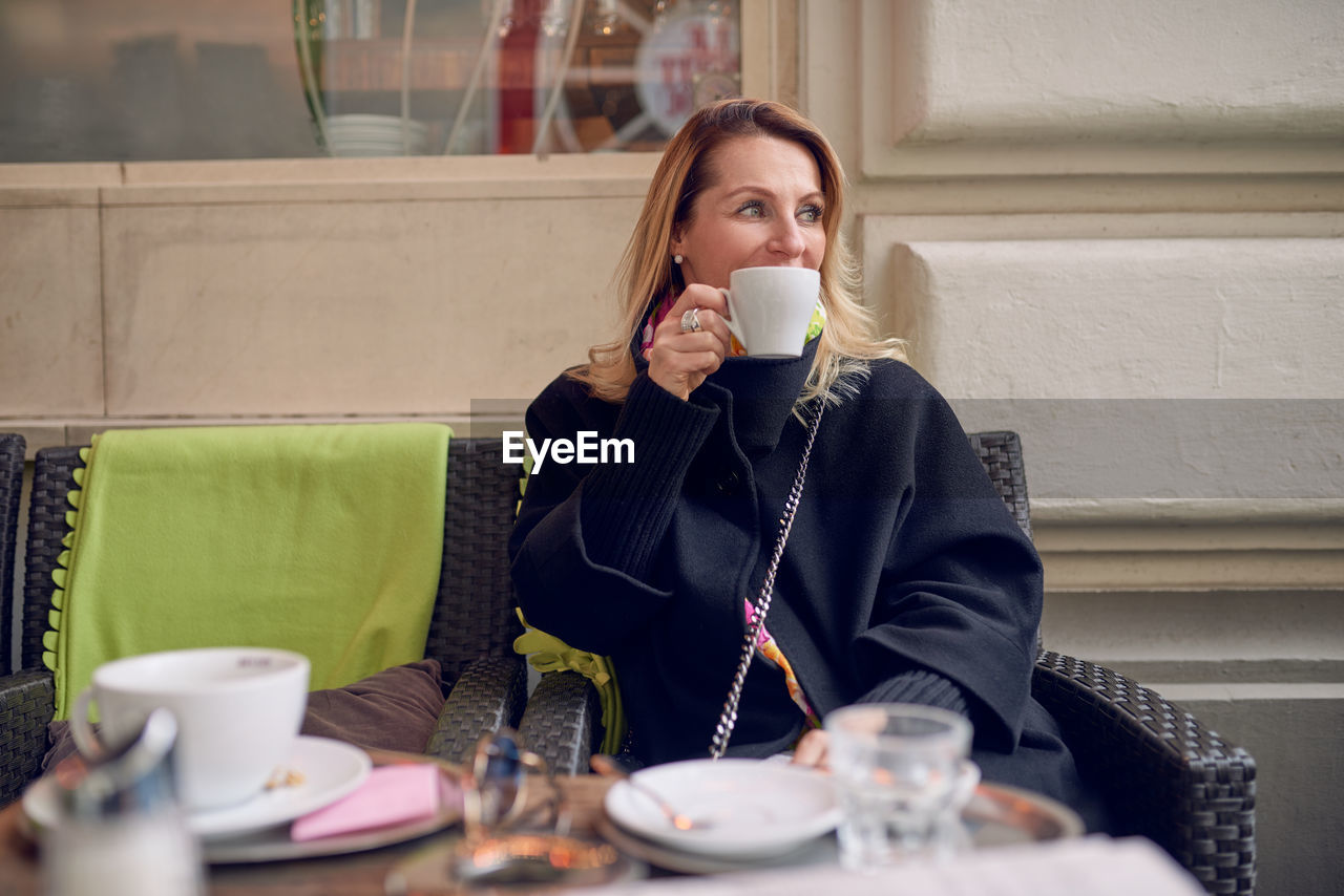 Young woman drinking coffee at restaurant