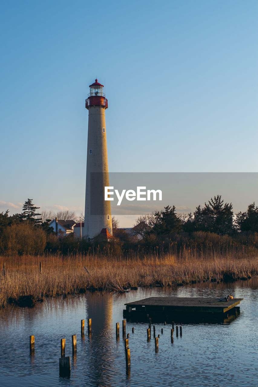 Lighthouse by lake against sky