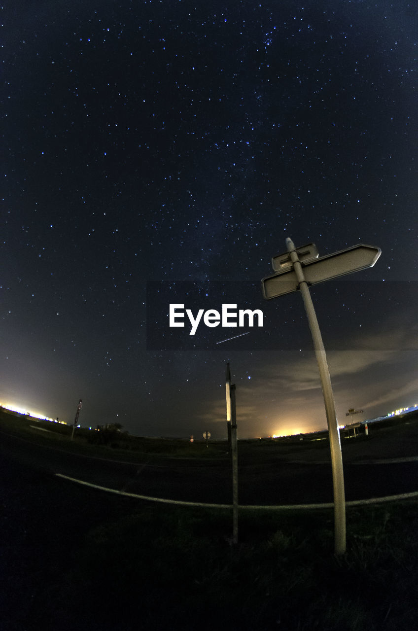 Low angle view of pole on street against sky with star field at night