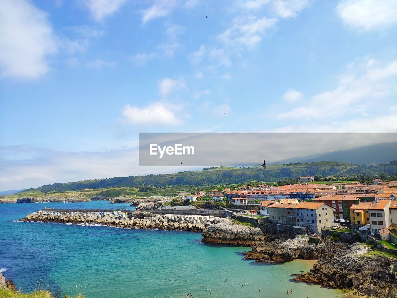 Scenic view of sea by buildings against sky