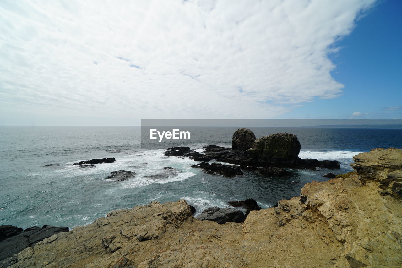 ROCKS ON BEACH AGAINST SKY