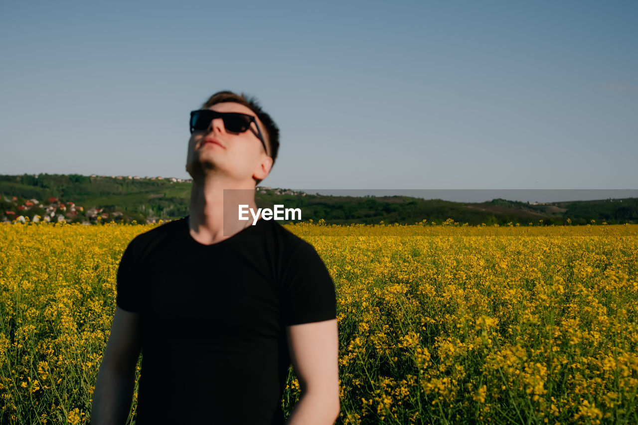 Portrait of woman standing on field against sky