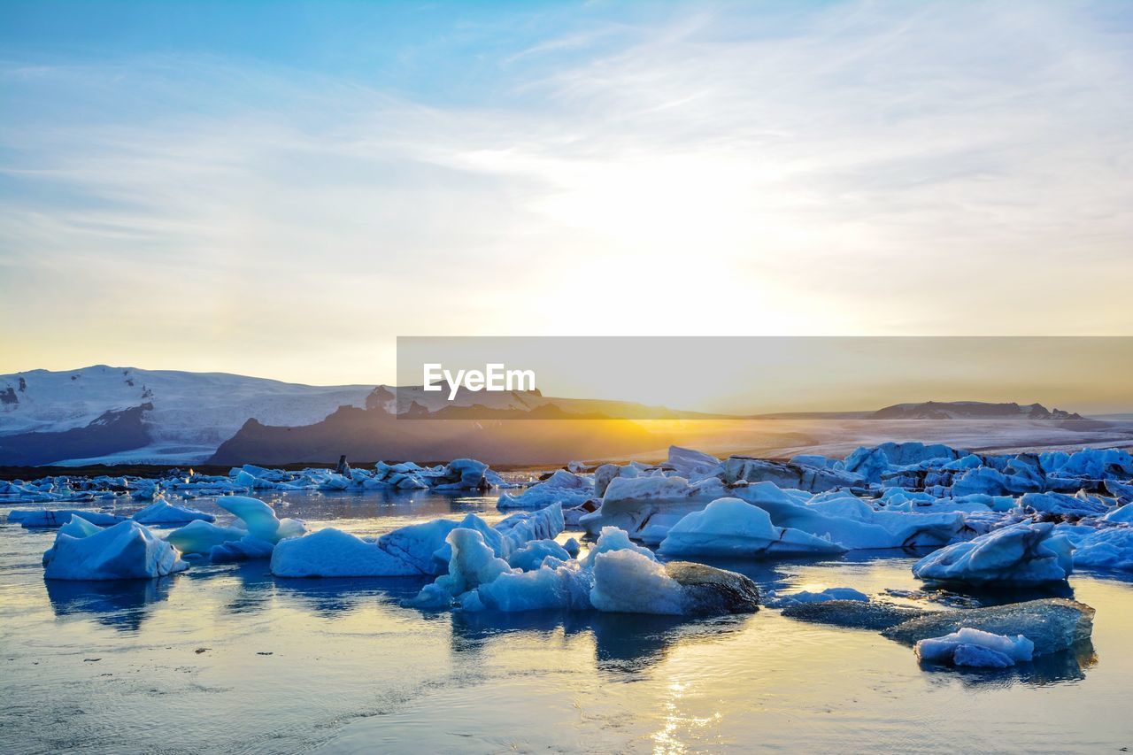 SCENIC VIEW OF FROZEN LAKE AGAINST SKY DURING WINTER