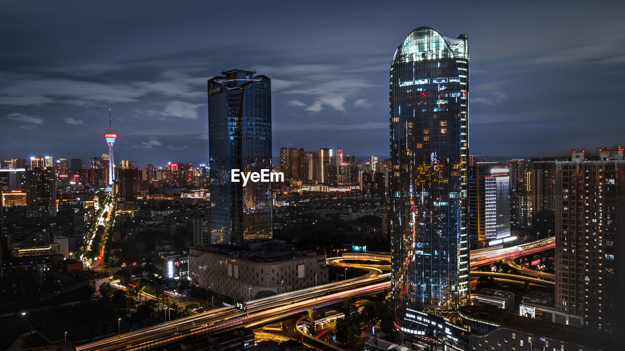 high angle view of illuminated cityscape against sky at night
