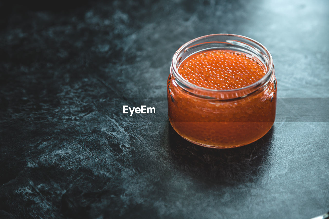 Red salted salmon caviar in a glass jar, fish caviar delicacy