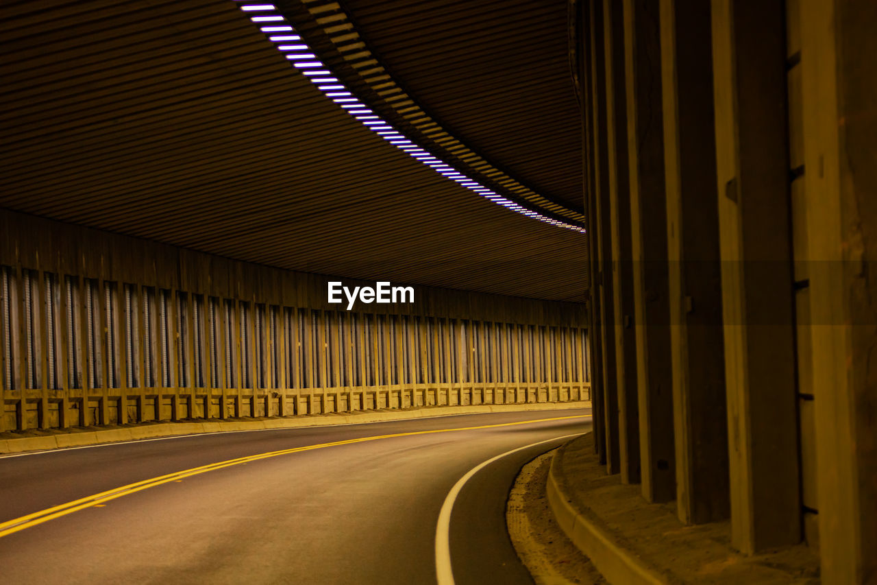 Empty road in illuminated tunnel