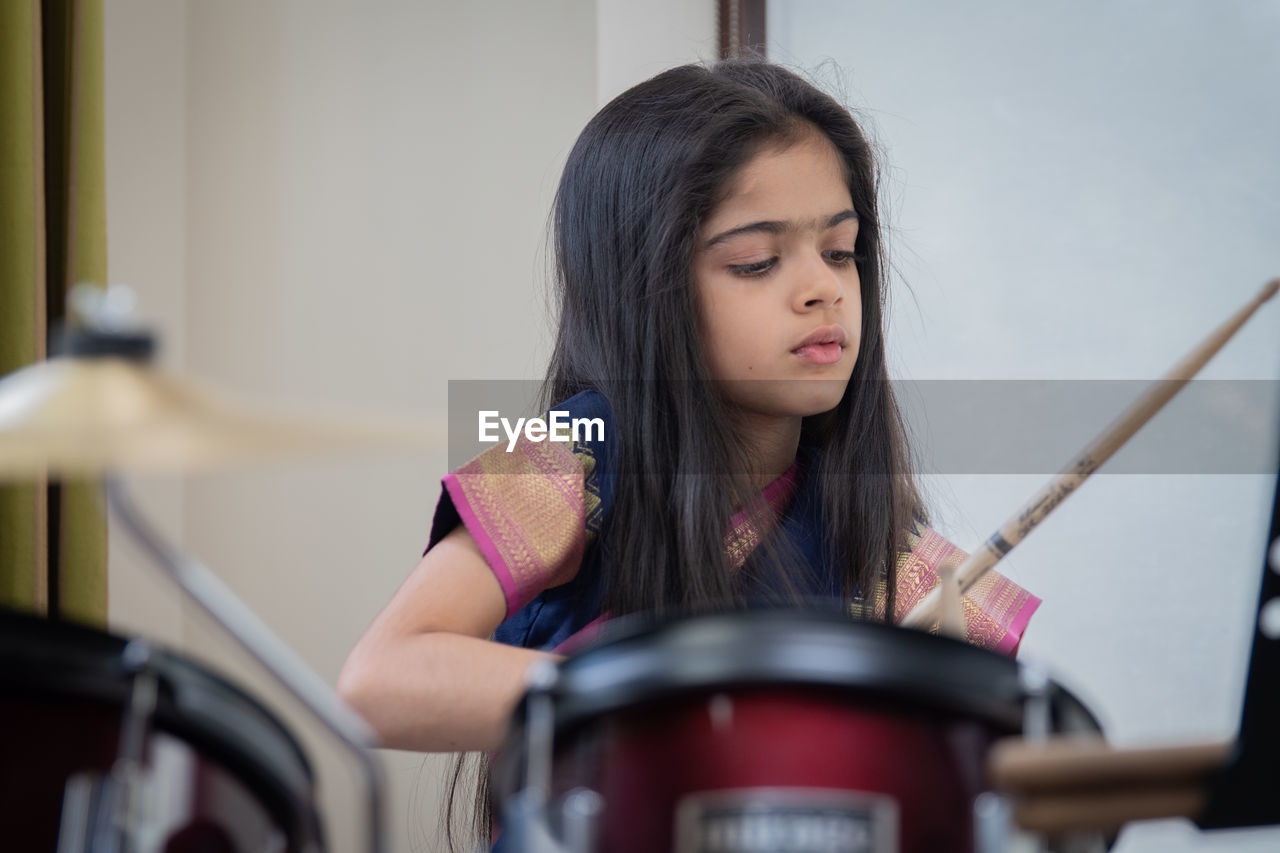 Girl in sari playing drum