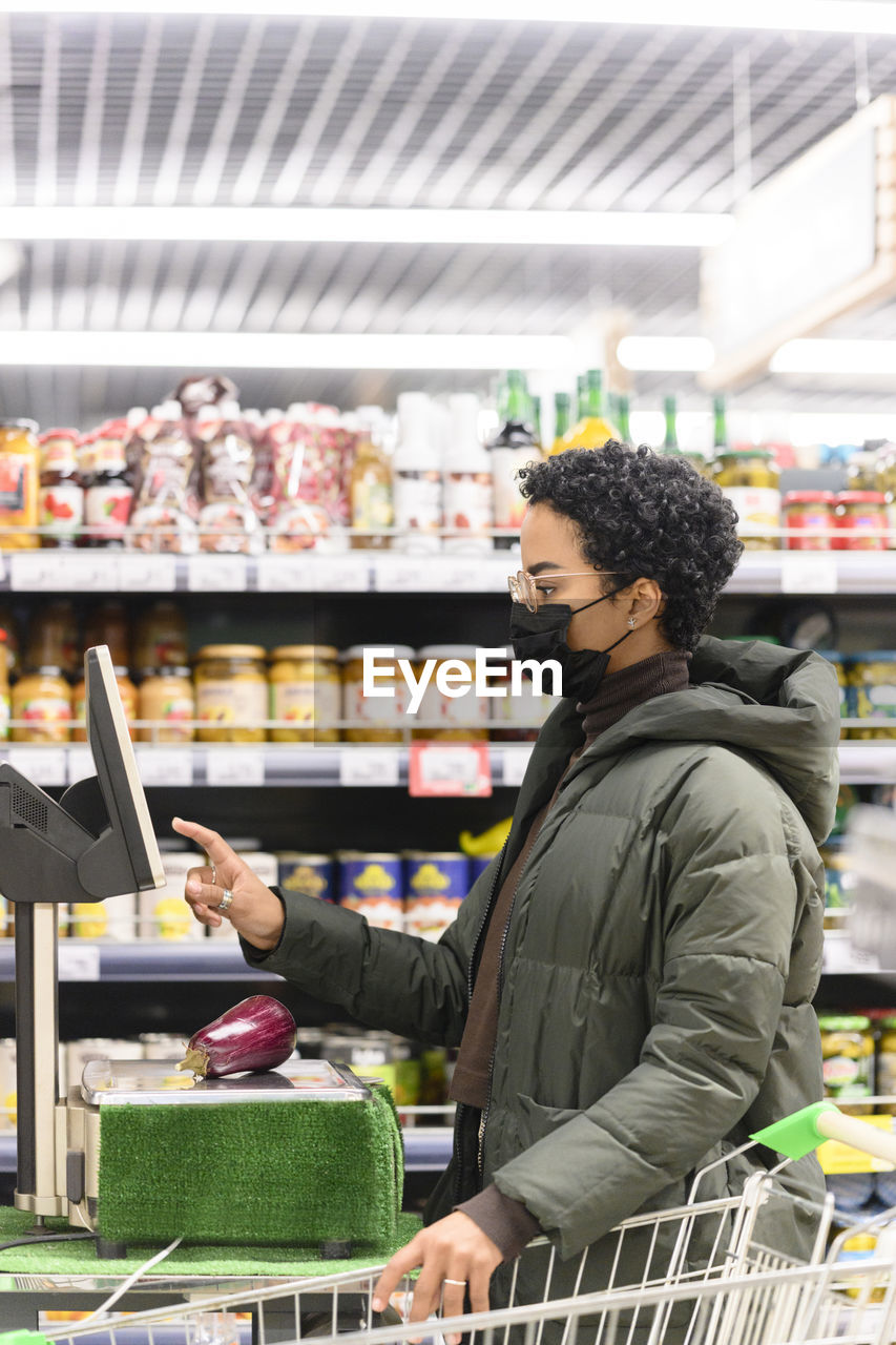 Young female making payment in supermarket