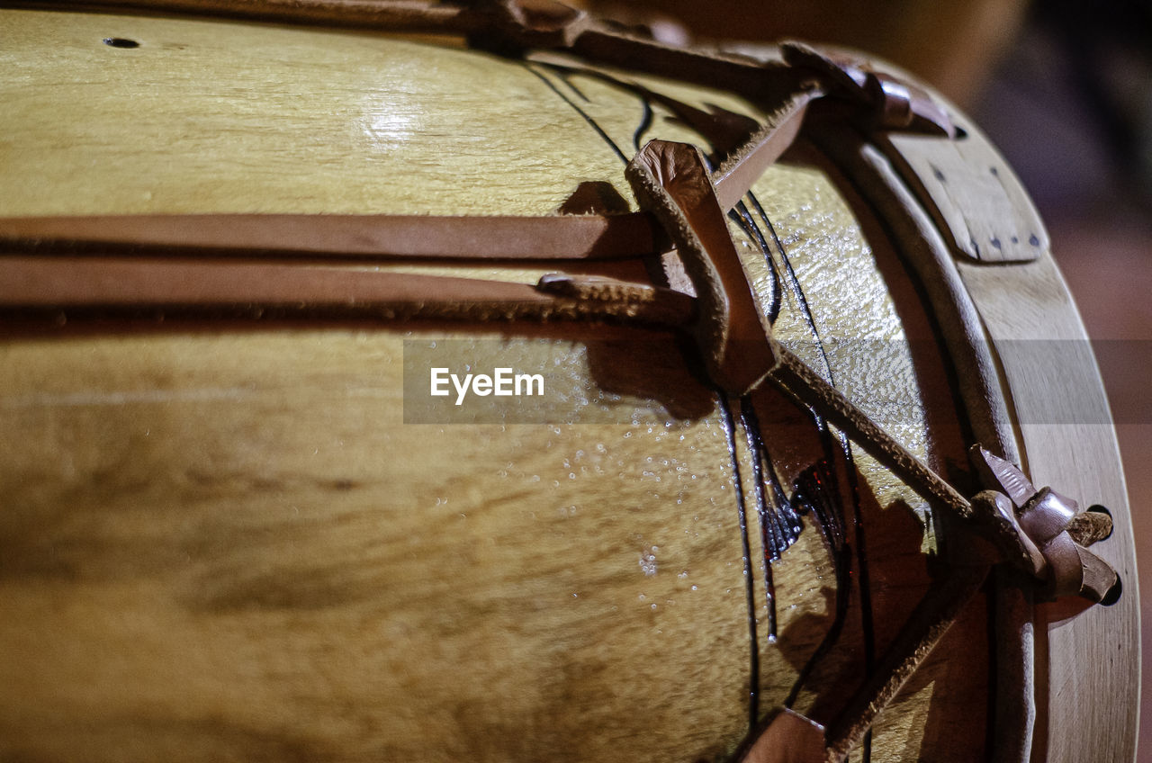 drum, close-up, wood, bridle, hand, string instrument, musical instrument, music, horse tack, membranophone, indoors, plucked string instruments, arts culture and entertainment, glasses