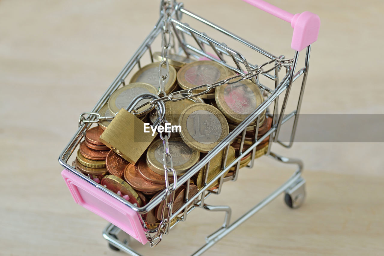 High angle view of coins in shopping cart