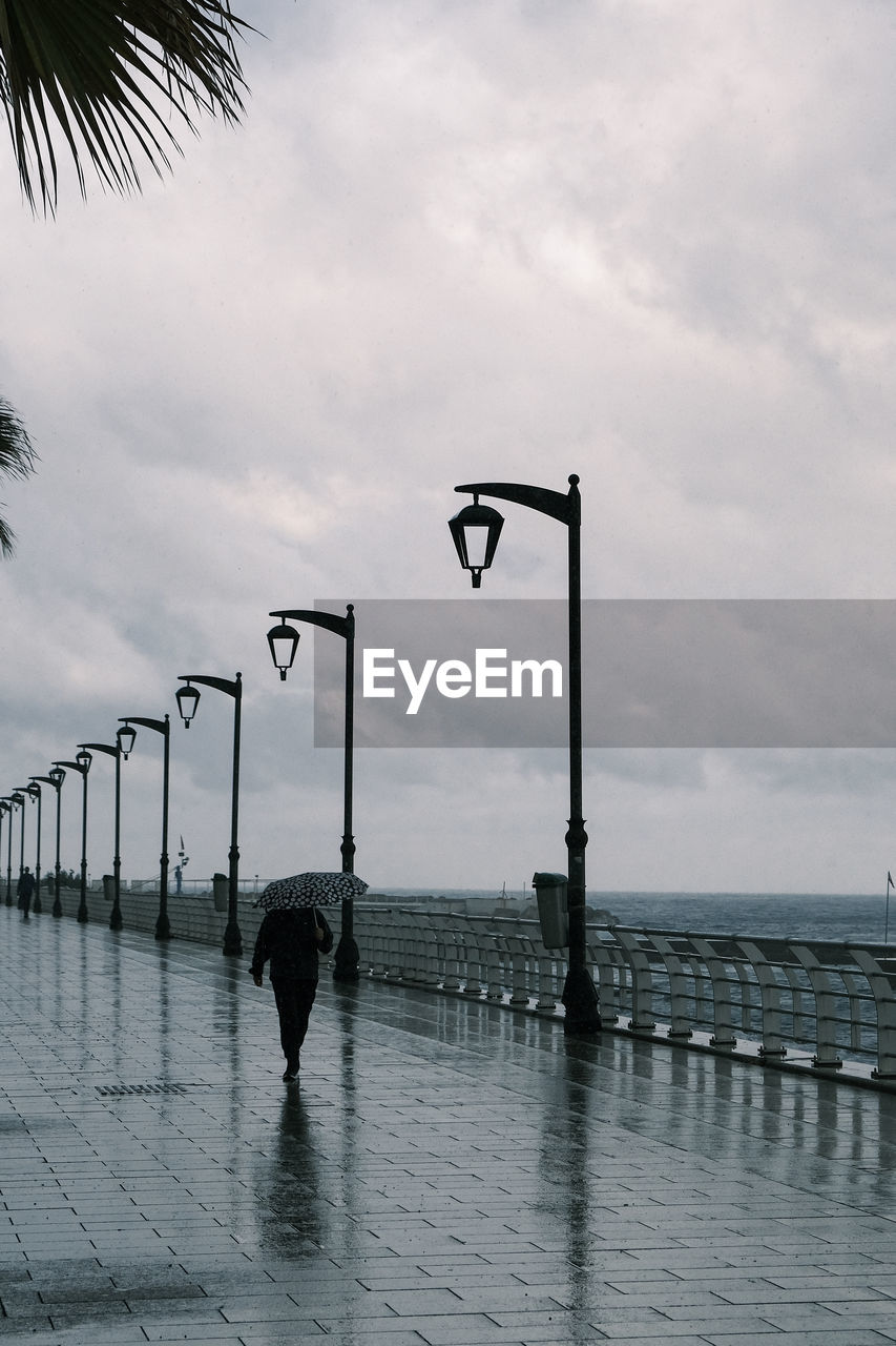 water, sky, nature, cloud, sea, ocean, beach, reflection, day, street light, architecture, black and white, outdoors, tropical climate, street, coast, palm tree, silhouette, walkway, beauty in nature, pier, monochrome, no people, tree