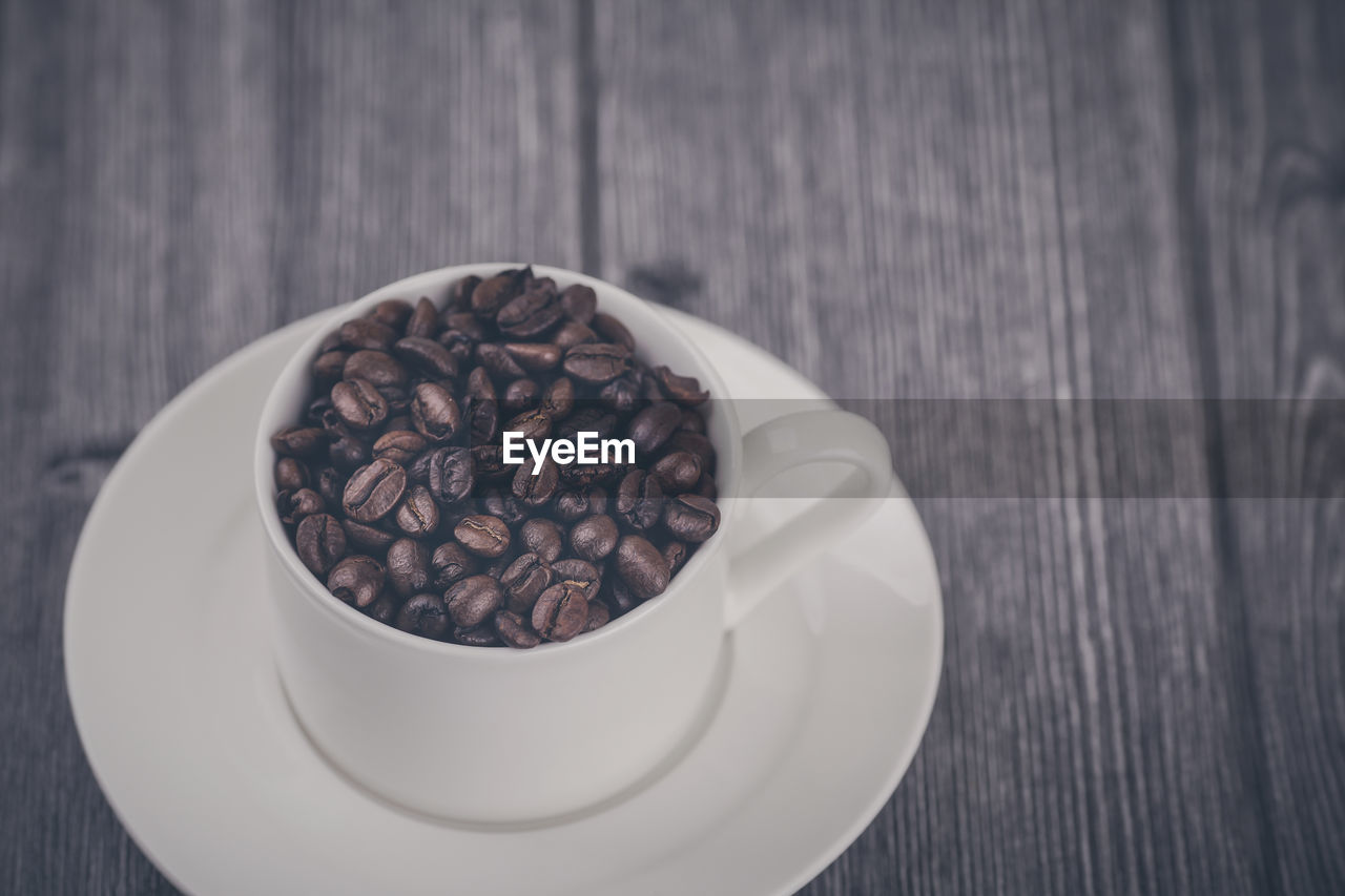 HIGH ANGLE VIEW OF COFFEE BEANS IN CUP ON TABLE