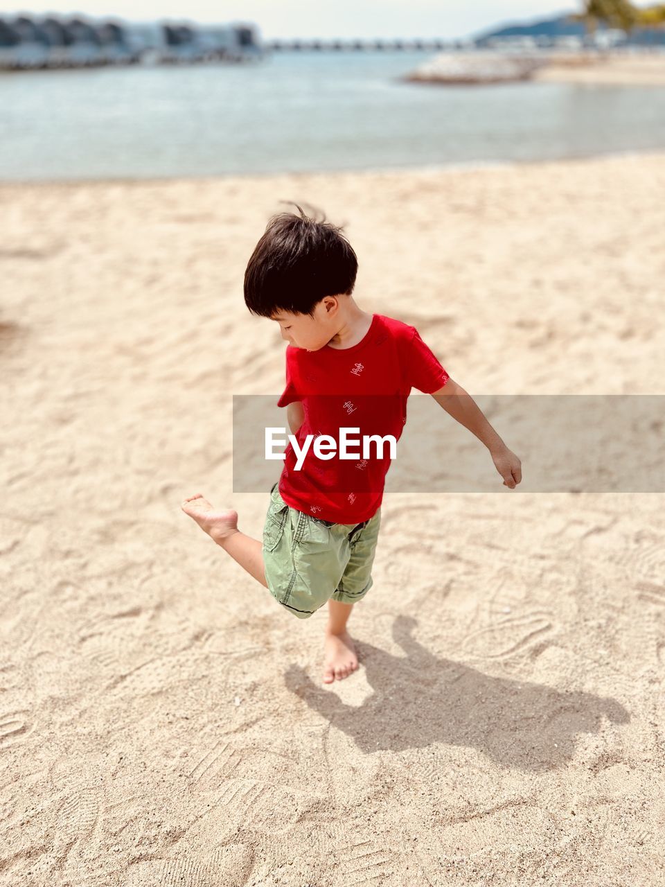 childhood, child, beach, sand, land, one person, full length, men, nature, water, sea, toddler, fun, day, red, innocence, holiday, barefoot, leisure activity, motion, vacation, person, baby, casual clothing, outdoors, trip, clothing, sunlight, happiness, emotion, cute, enjoyment, summer, focus on foreground, carefree, lifestyles, sky