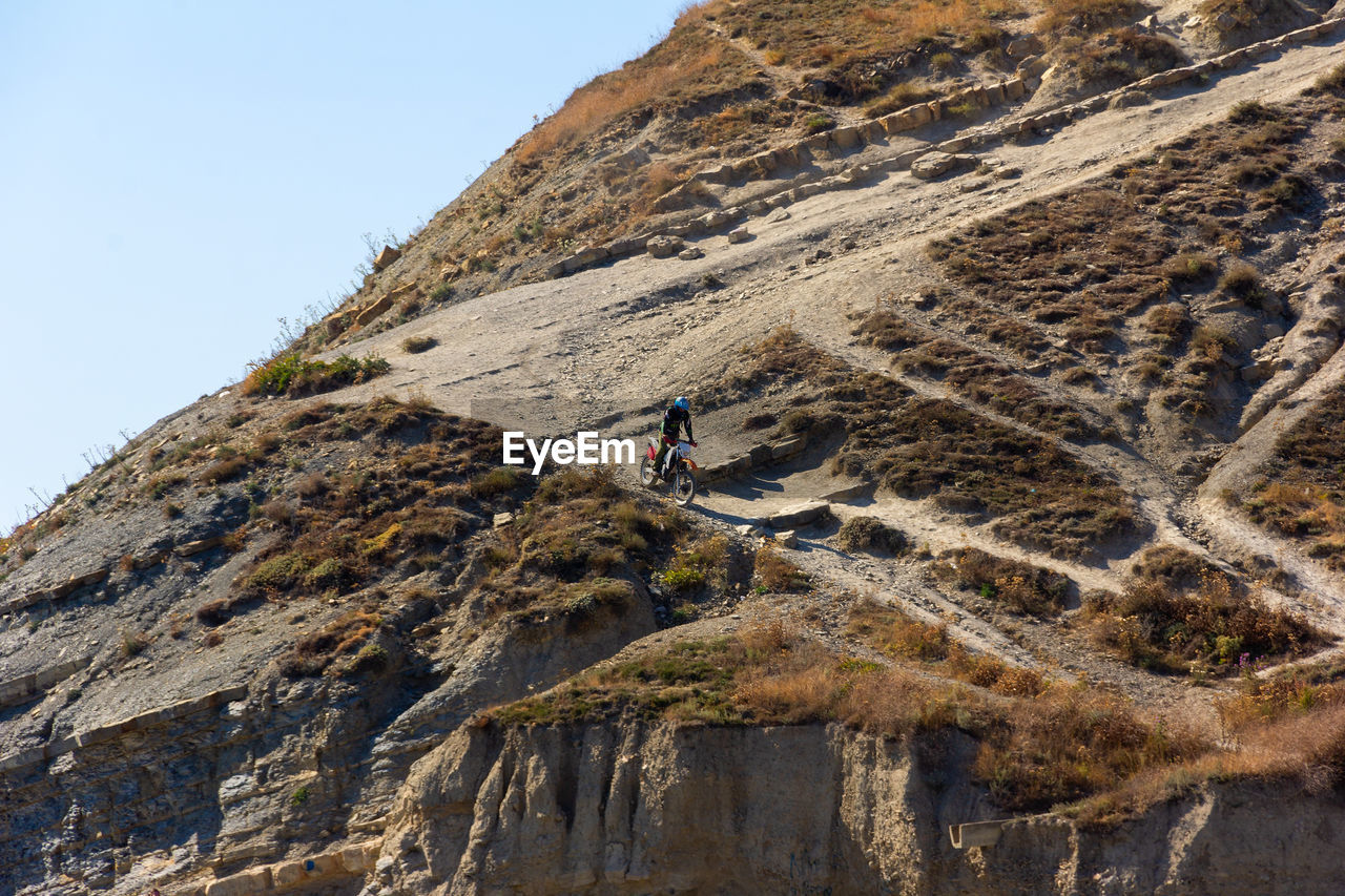 Extreme enduro motorcycle driving, a young guy drives down a steep mountain