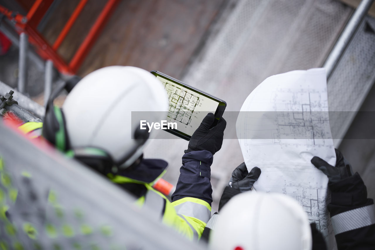 Engineers using digital tablet at building site