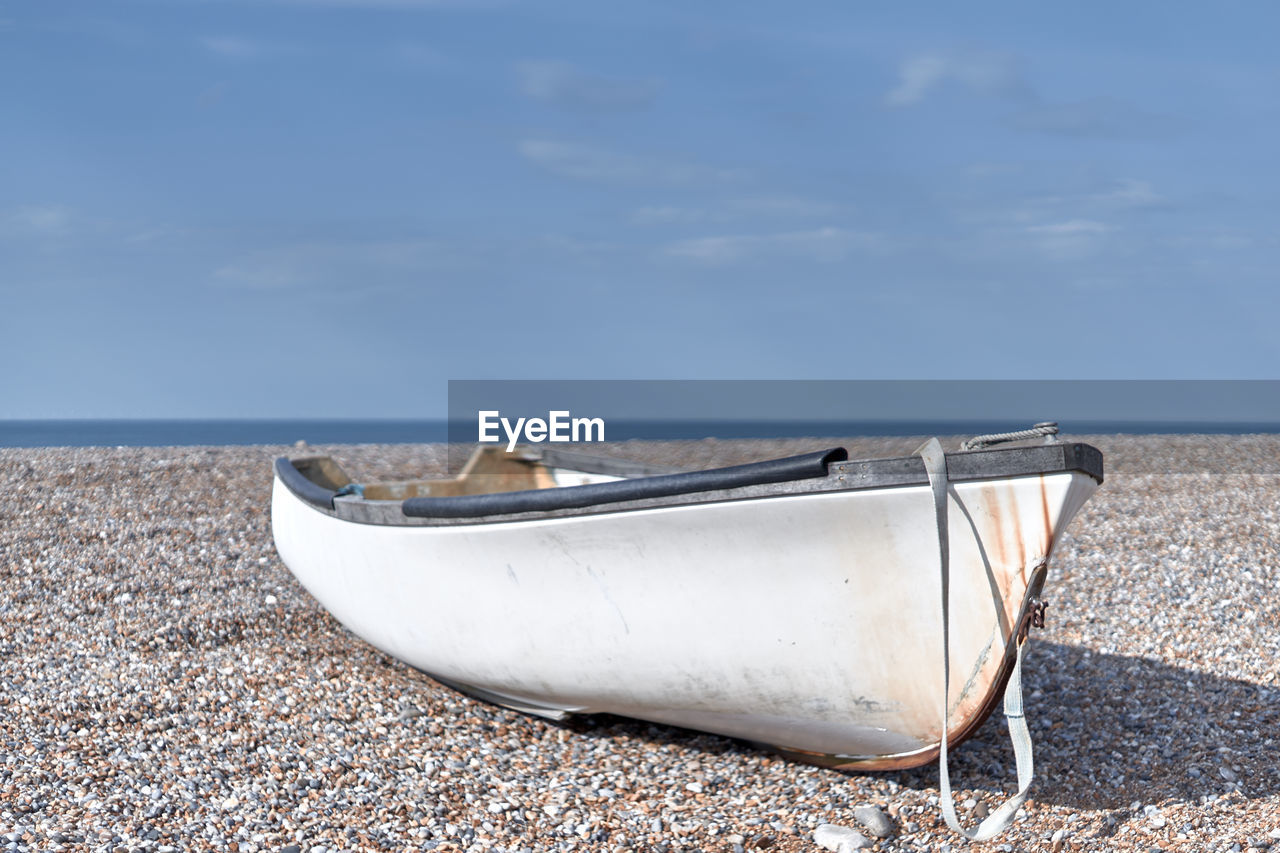 Lonely white boat on the beach in blurred background.