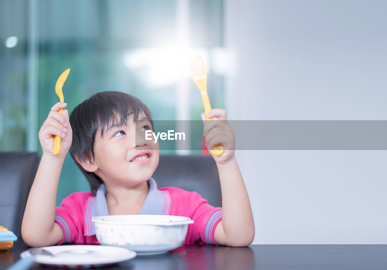 PORTRAIT OF CUTE BOY EATING FOOD