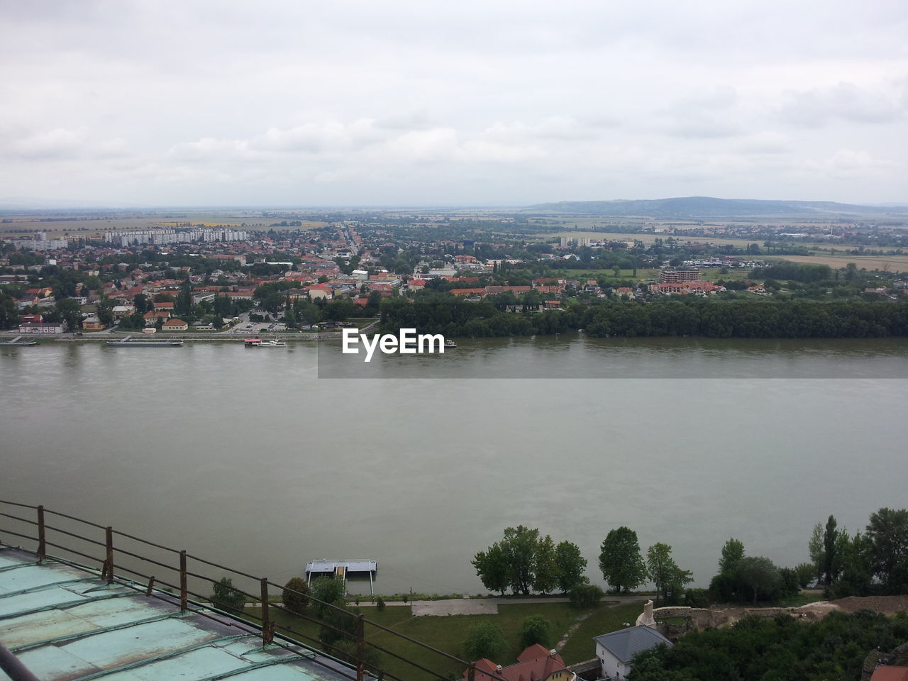 Cityscape by river against sky