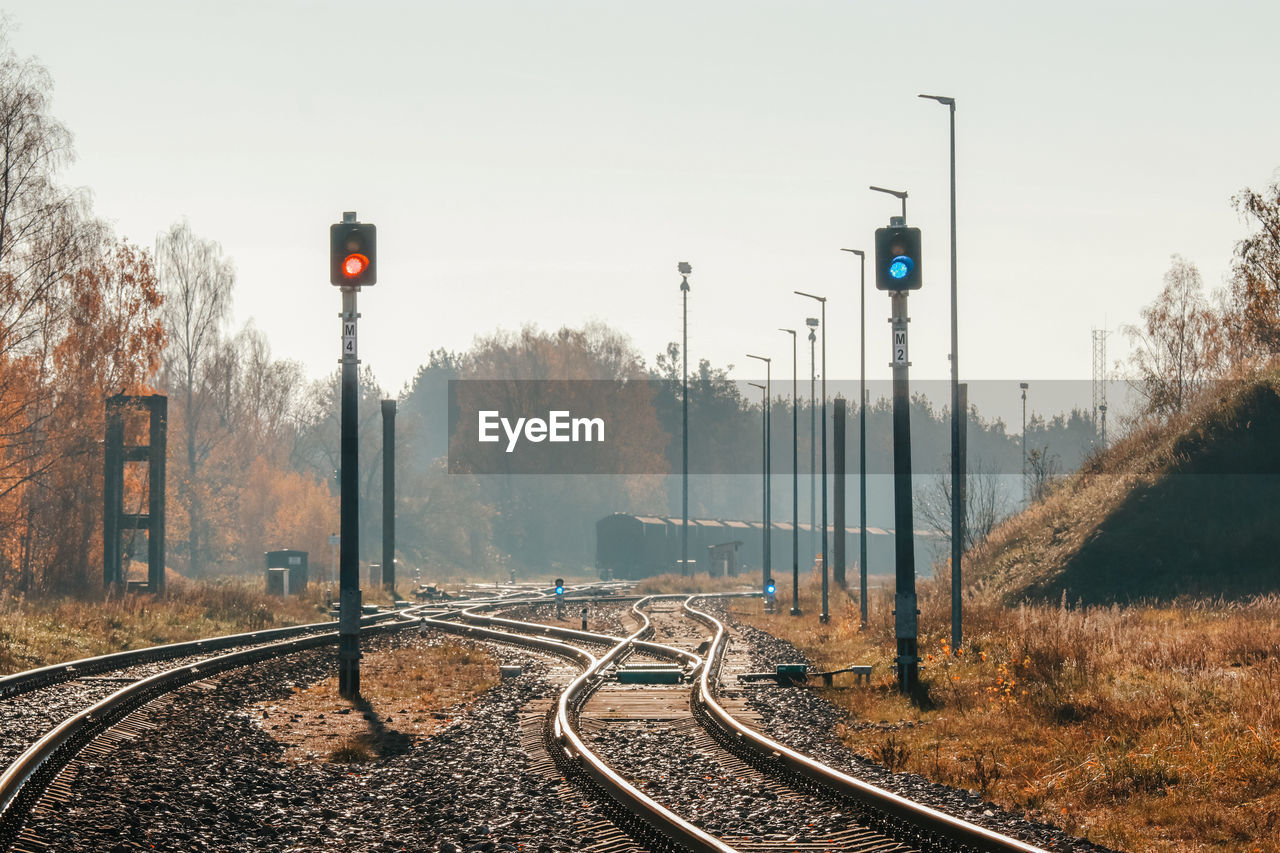 Railroad tracks by trees against sky