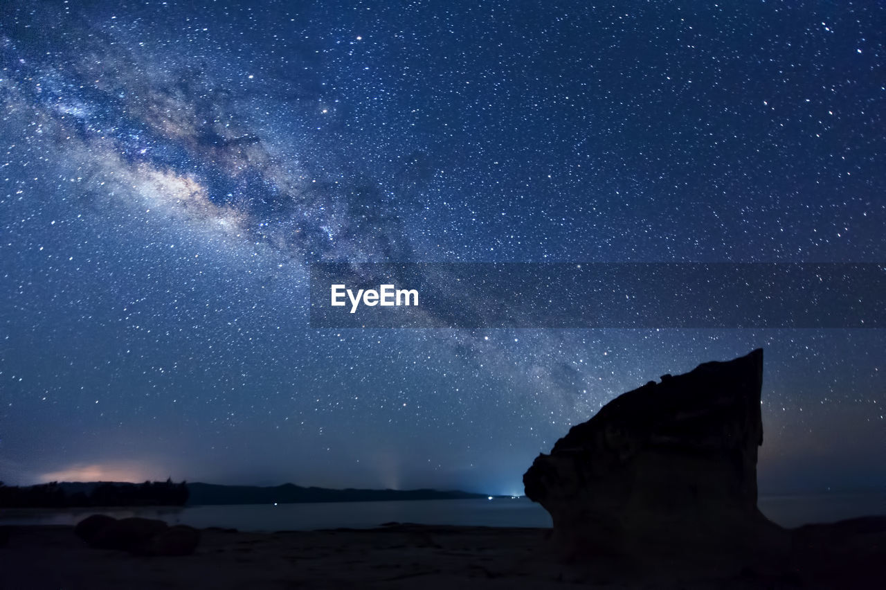 View of star field over beach at night