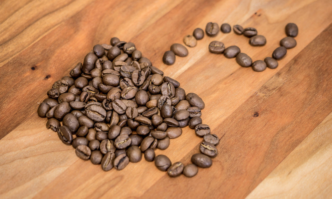 High angle view of roasted coffee beans on wooden table