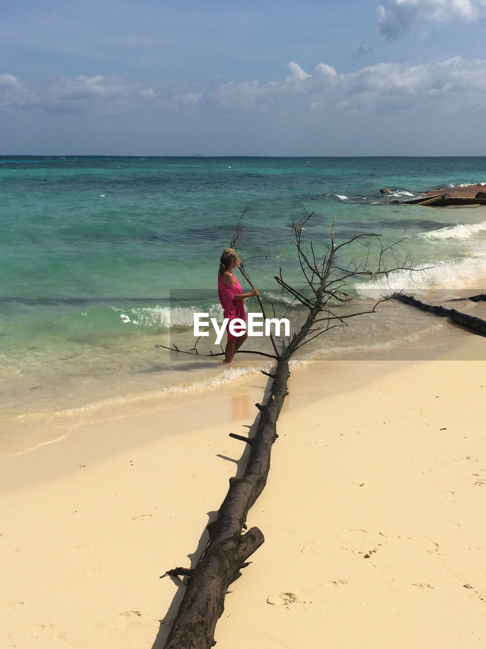 WOMAN ON BEACH AGAINST SEA