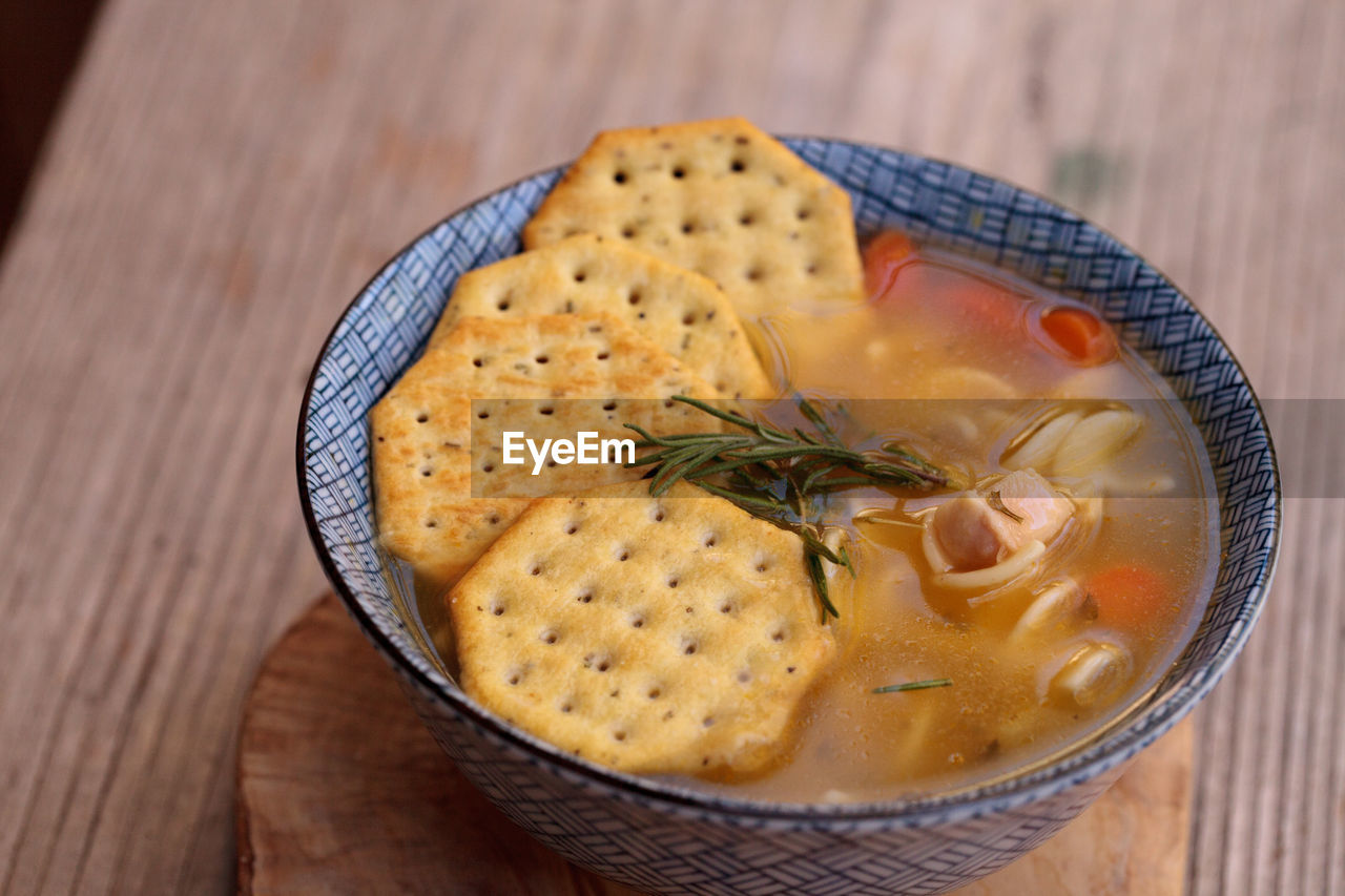 High angle view of soup with crackers on wooden table