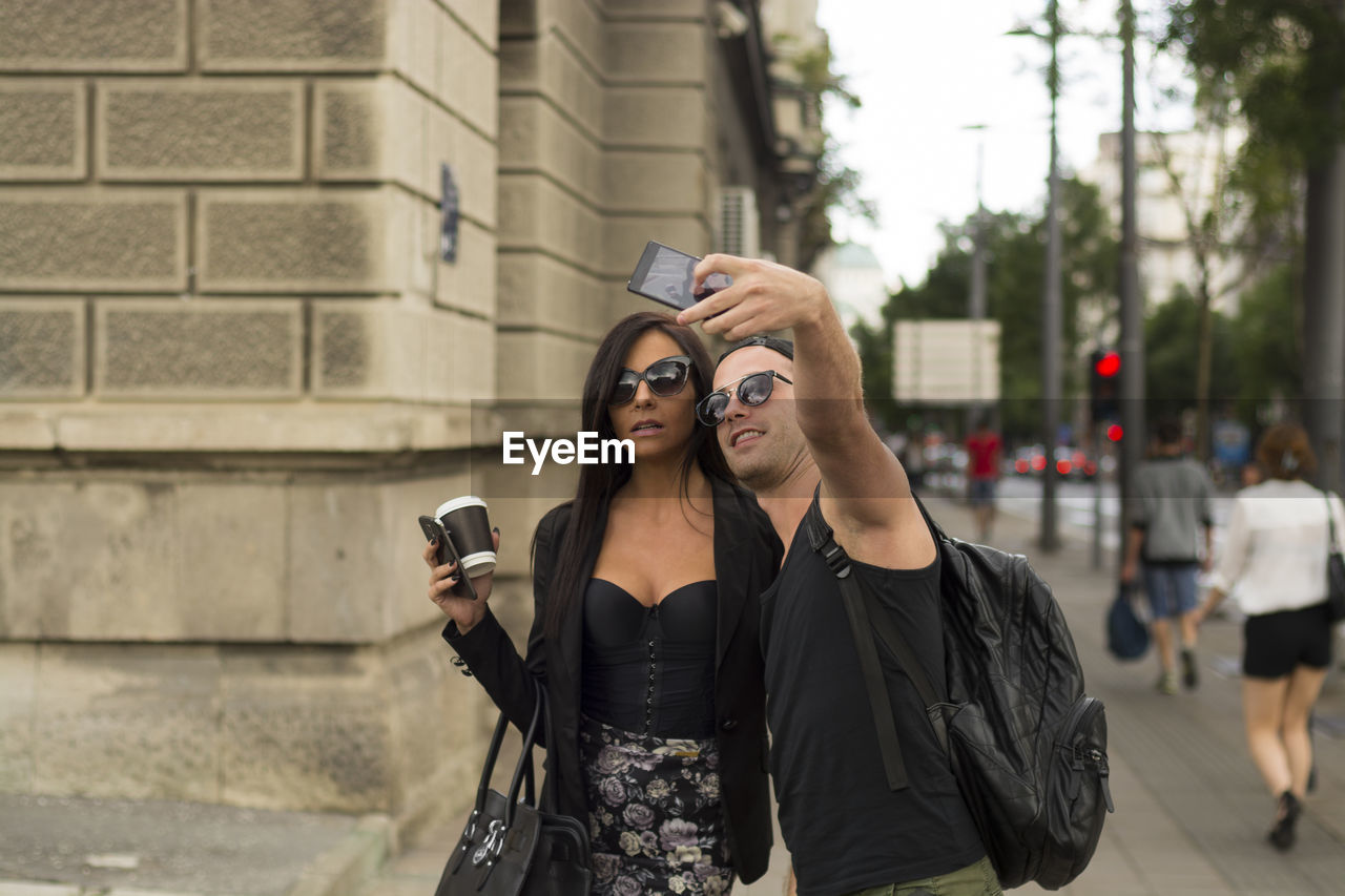 Man taking selfie with friend while standing on road