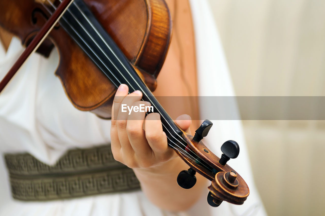 Midsection of woman playing violin