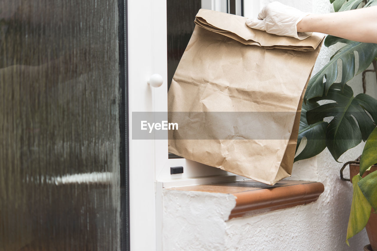 Cropped hand of person holding bags outdoors