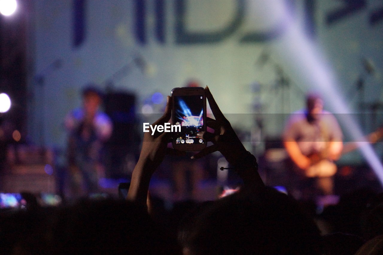People photographing through smart phone at concert