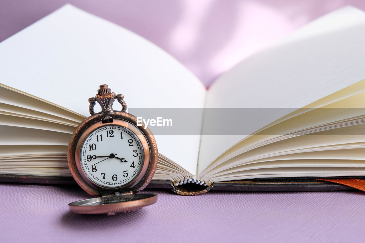 CLOSE-UP OF CLOCK ON TABLE AGAINST WALL