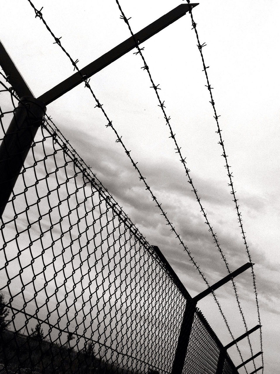 Low angle view of silhouette barbed wire against sky at dusk
